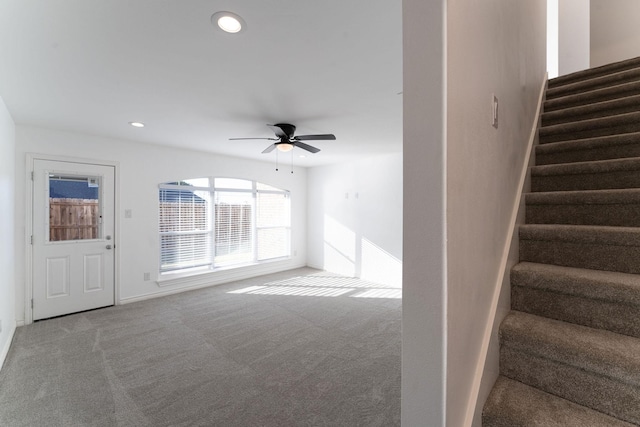 interior space with ceiling fan and carpet