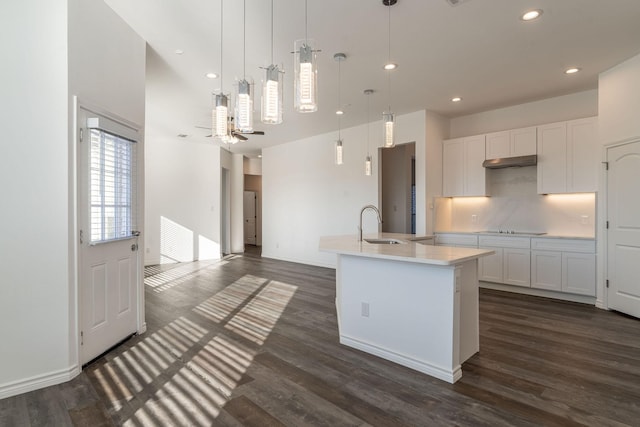 kitchen featuring pendant lighting, white cabinets, dark hardwood / wood-style floors, and a kitchen island with sink