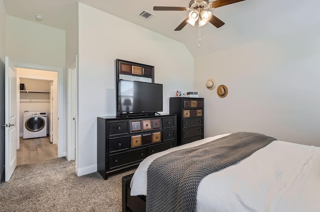 carpeted bedroom with vaulted ceiling, washer / dryer, a spacious closet, ceiling fan, and a closet