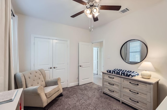 sitting room with ceiling fan and dark carpet