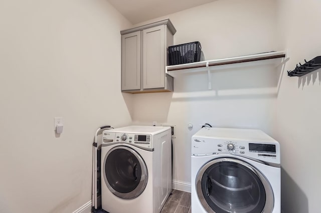 clothes washing area featuring cabinets and washing machine and clothes dryer