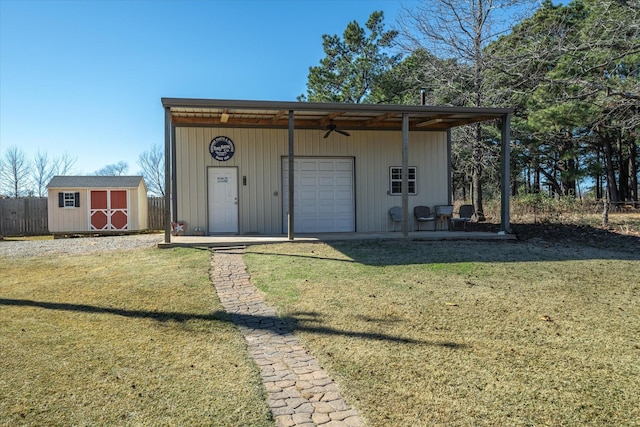 view of front of home with a garage, a front lawn, and a shed