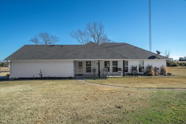 rear view of house featuring a yard