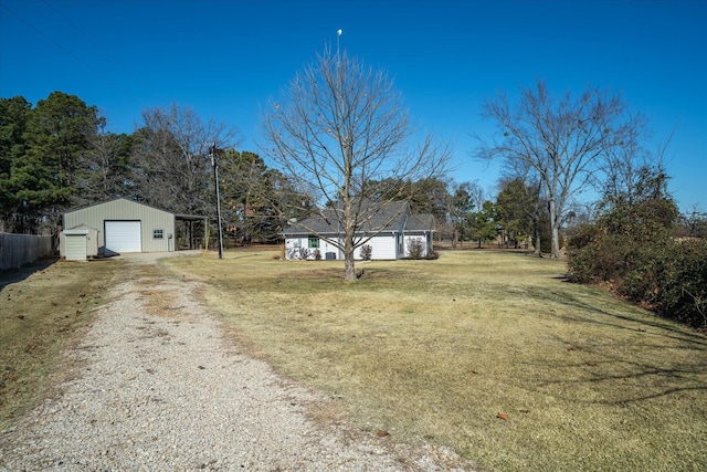 view of yard with a garage and an outbuilding