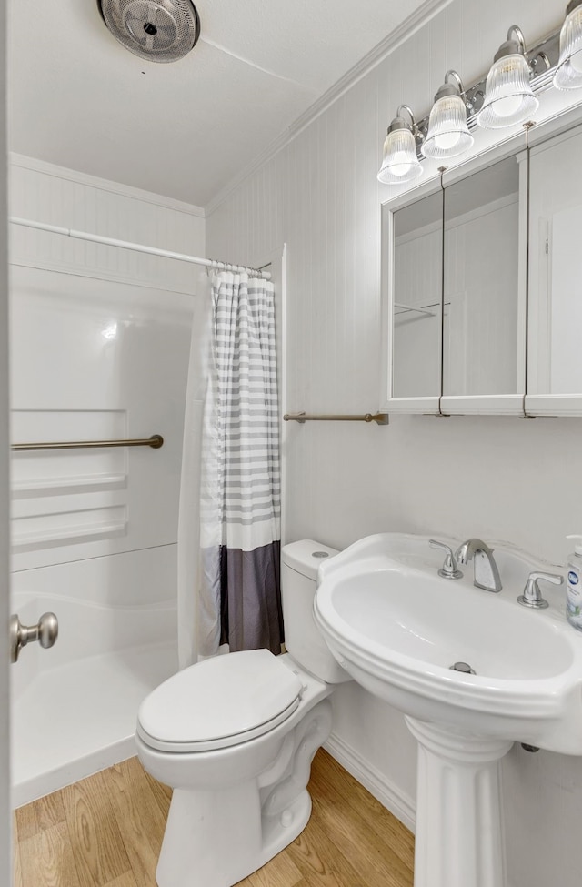 bathroom with a shower with curtain, hardwood / wood-style floors, toilet, and crown molding