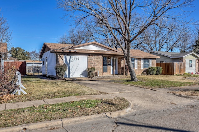 ranch-style house featuring a garage and a front lawn