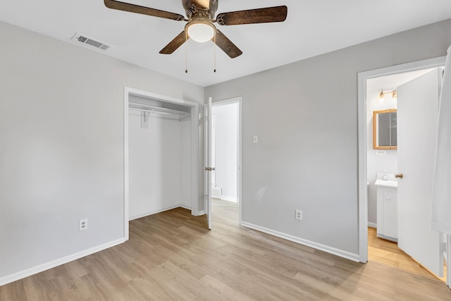 unfurnished bedroom featuring ceiling fan, connected bathroom, a closet, and light wood-type flooring