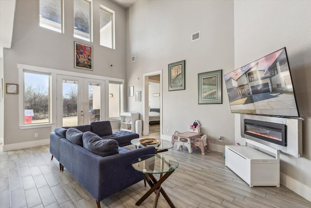 living room with a high ceiling and french doors