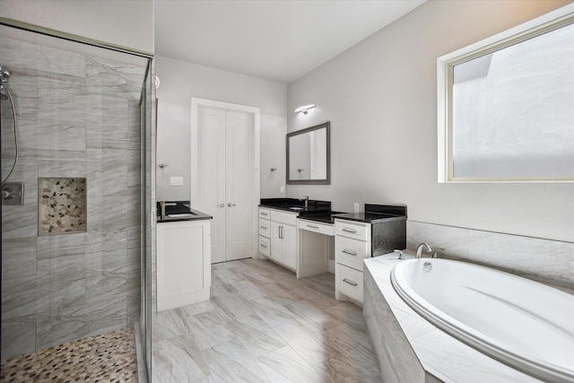 bathroom featuring a bath, a stall shower, and vanity