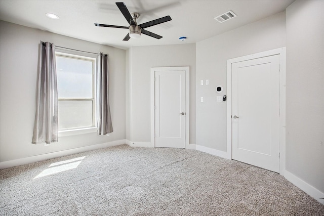carpeted empty room featuring visible vents, baseboards, and a ceiling fan