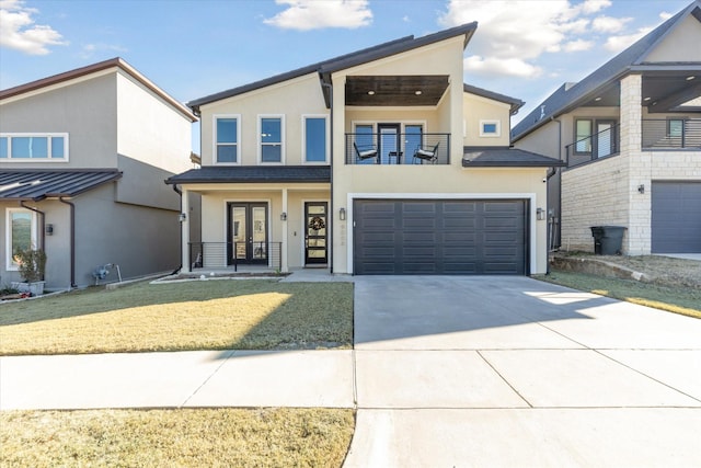 view of front of property featuring a balcony, a front lawn, a garage, and french doors