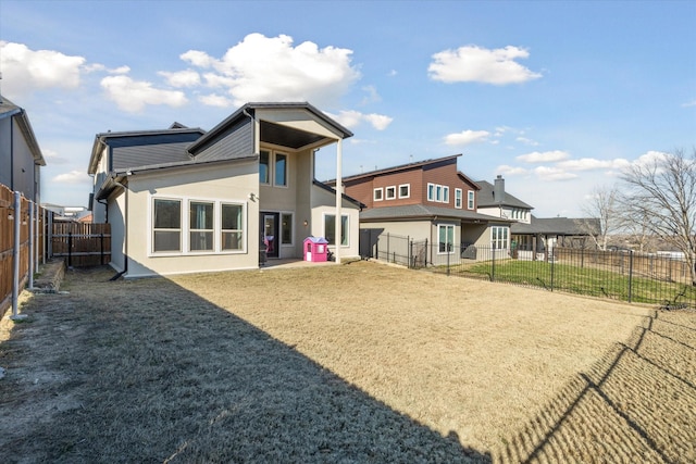 back of house featuring a patio and a yard