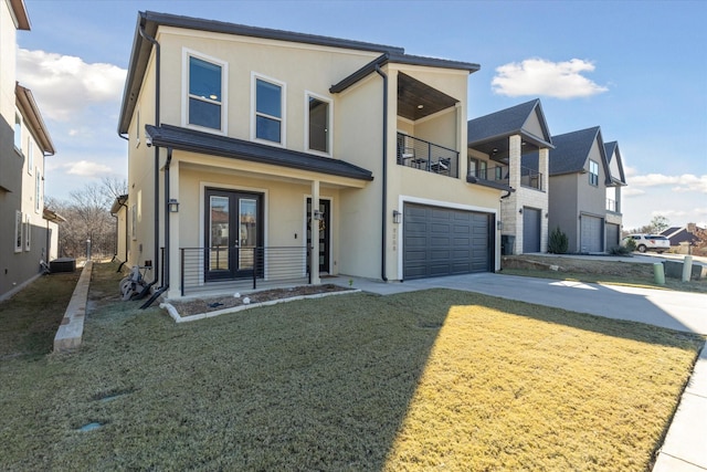 view of front of home with concrete driveway, a balcony, stucco siding, french doors, and a garage