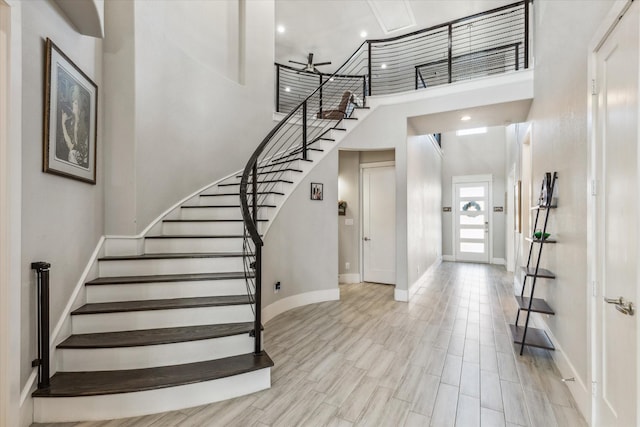 entrance foyer with a towering ceiling and light wood-type flooring