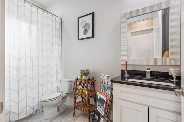 bathroom with vanity, a shower with shower curtain, and toilet