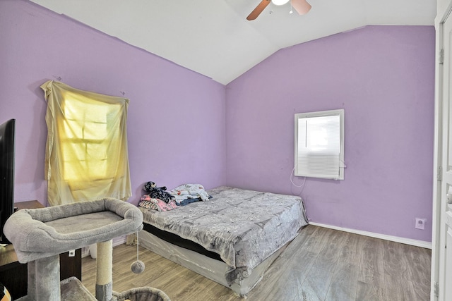 bedroom with ceiling fan, wood-type flooring, and vaulted ceiling