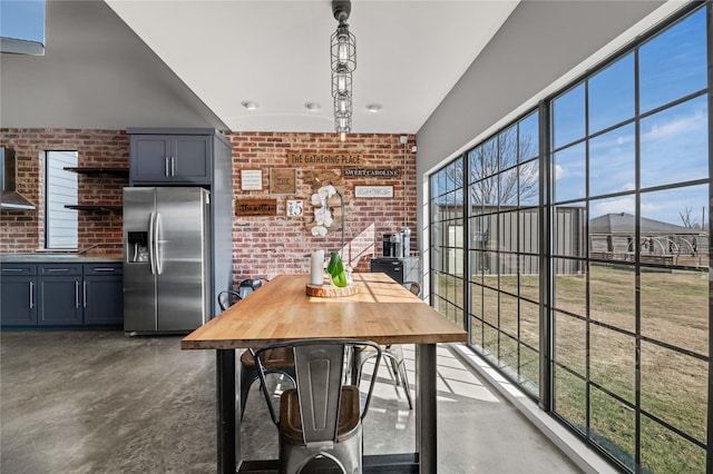 dining area with concrete floors and brick wall