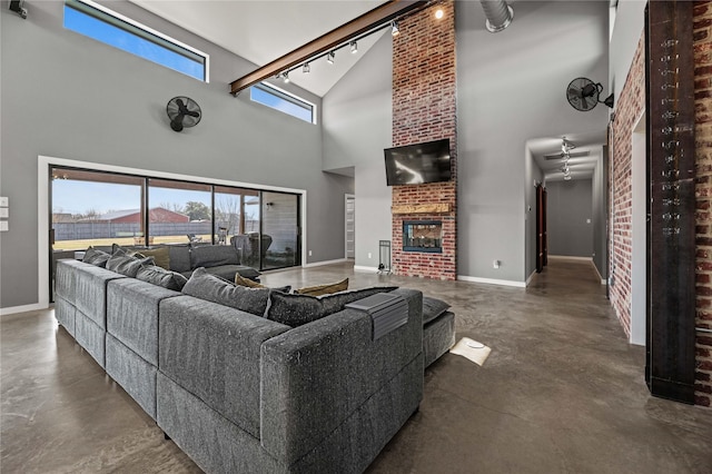 living room featuring a towering ceiling and a brick fireplace