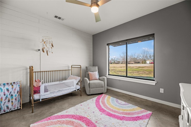 bedroom with ceiling fan and a crib