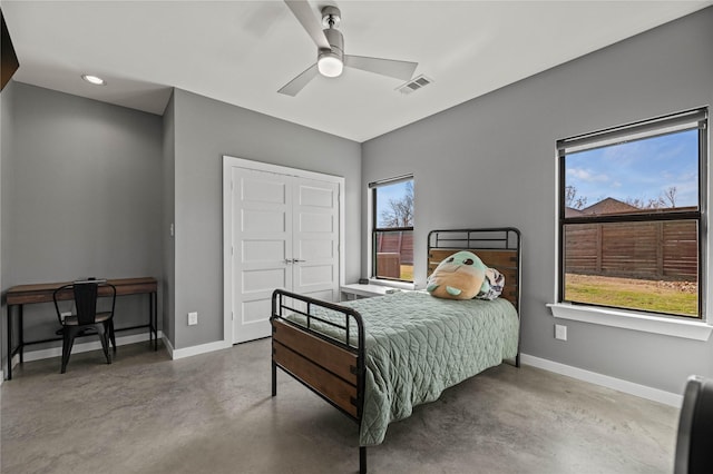 bedroom with a closet, ceiling fan, and concrete flooring