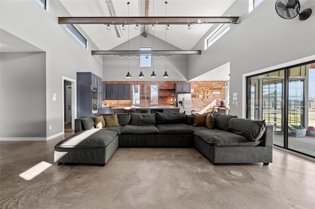 living room with concrete floors and high vaulted ceiling