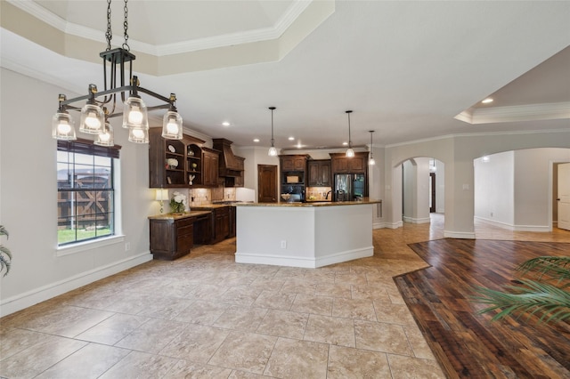 10545 Lago Vis, Quinlan, TX 75474 - kitchen with stainless steel fridge with ice dispenser, arched walkways, premium range hood, dark brown cabinetry, and open floor plan
