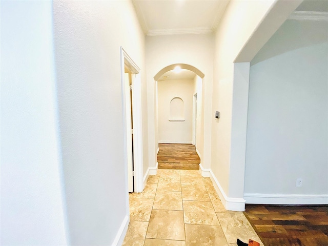 hall with ornamental molding and light tile patterned floors