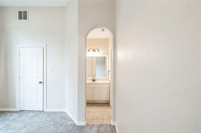 10545 Lago Vis, Quinlan, TX 75474 - hallway featuring a sink, light colored carpet, baseboards, and arched walkways