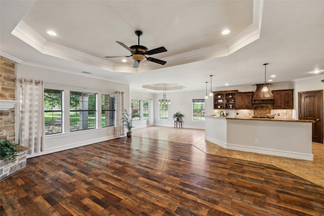 10545 Lago Vis, Quinlan, TX 75474 - unfurnished living room featuring wood-type flooring, a tray ceiling, ceiling fan, ornamental molding, and recessed lighting