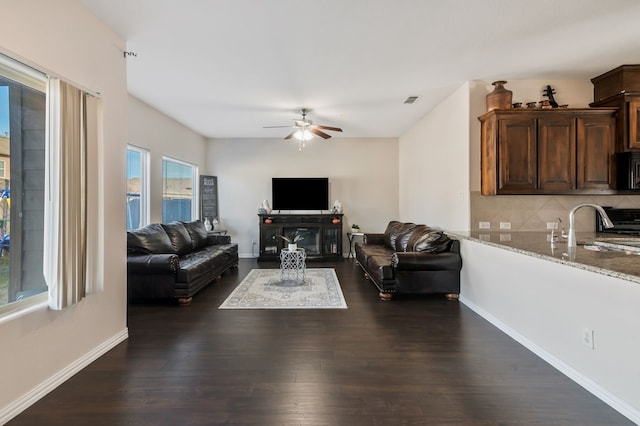 living room with sink, ceiling fan, and dark hardwood / wood-style flooring