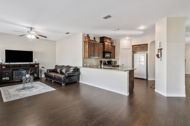 living room featuring dark wood-type flooring, sink, and ceiling fan