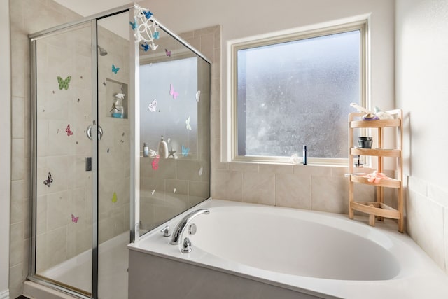 bathroom featuring shower with separate bathtub