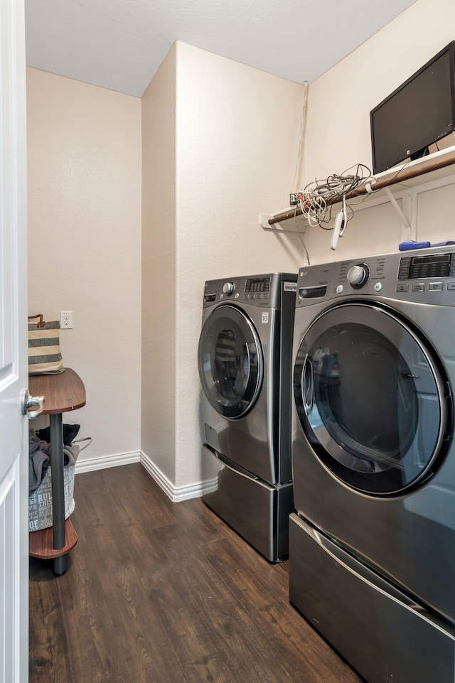 washroom with washing machine and dryer and dark hardwood / wood-style floors