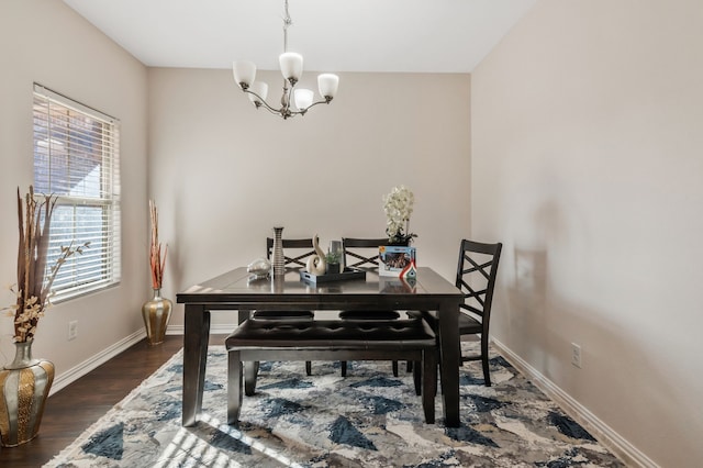 dining area with dark hardwood / wood-style flooring and a notable chandelier