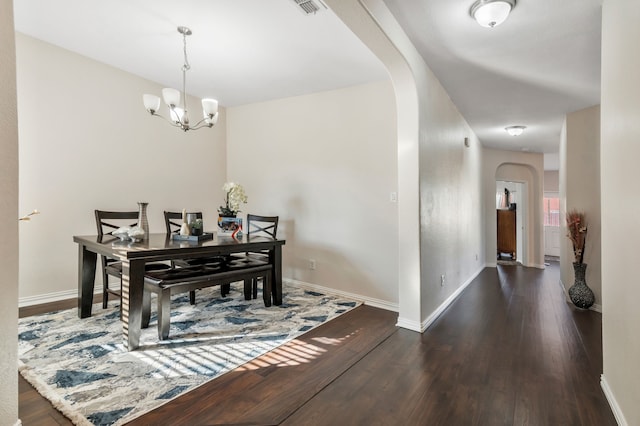 dining space featuring an inviting chandelier and dark wood-type flooring