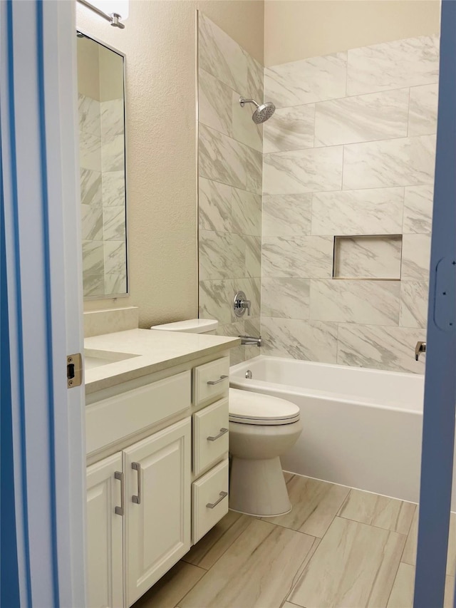 full bathroom featuring toilet, tiled shower / bath, and vanity