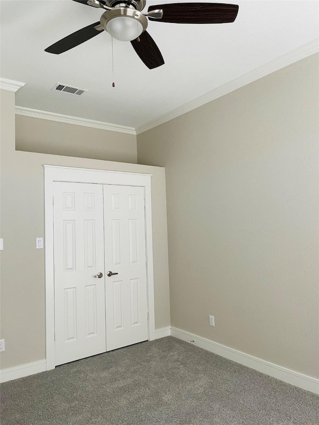 unfurnished bedroom featuring carpet, a closet, ceiling fan, and ornamental molding