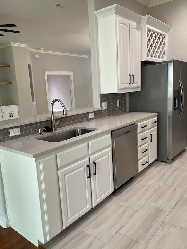 kitchen featuring white cabinetry, a sink, visible vents, stainless steel appliances, and ornamental molding