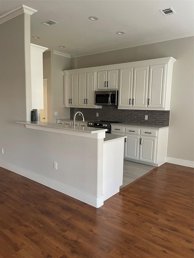 kitchen featuring electric stove, crown molding, white cabinets, and kitchen peninsula