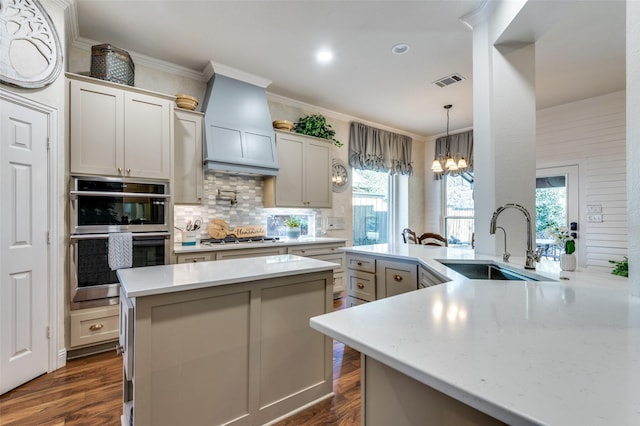 kitchen featuring kitchen peninsula, sink, dark wood-type flooring, decorative backsplash, and stainless steel appliances