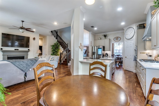 dining area featuring ceiling fan, dark hardwood / wood-style floors, and ornamental molding