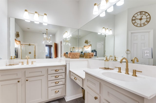 bathroom featuring an enclosed shower, vanity, and an inviting chandelier