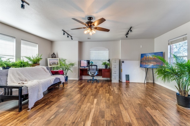 home office featuring ceiling fan, rail lighting, and wood-type flooring