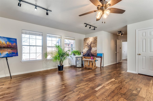 interior space with ceiling fan, dark wood-type flooring, and rail lighting