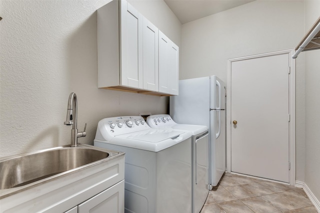 laundry room with sink, cabinets, washer and dryer, and light tile patterned floors