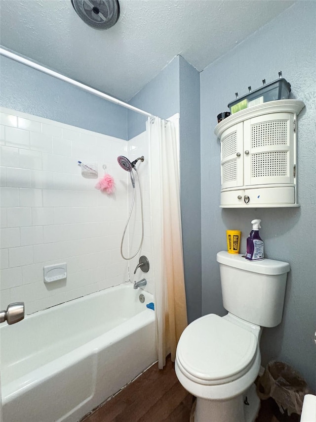 bathroom featuring hardwood / wood-style flooring, shower / bath combo, a textured ceiling, and toilet