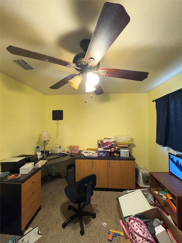 carpeted office space featuring ceiling fan