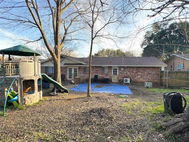 rear view of property with central air condition unit, a patio area, and a playground