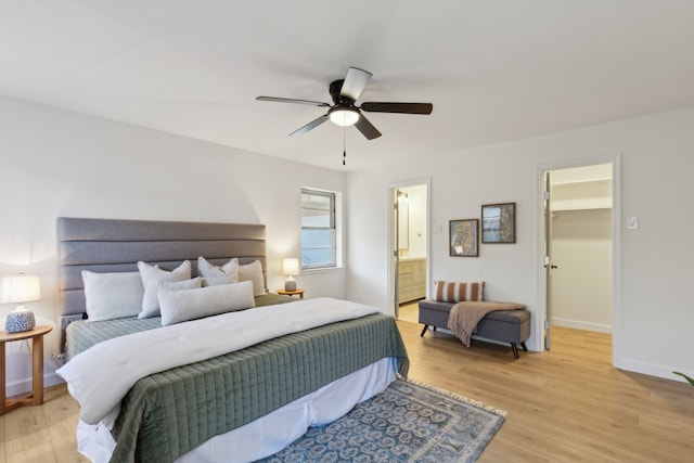 bedroom featuring ceiling fan, light hardwood / wood-style floors, a closet, and a walk in closet