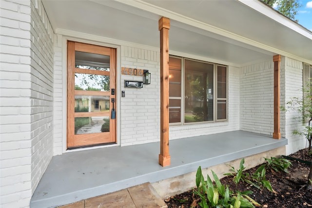 view of exterior entry with a porch